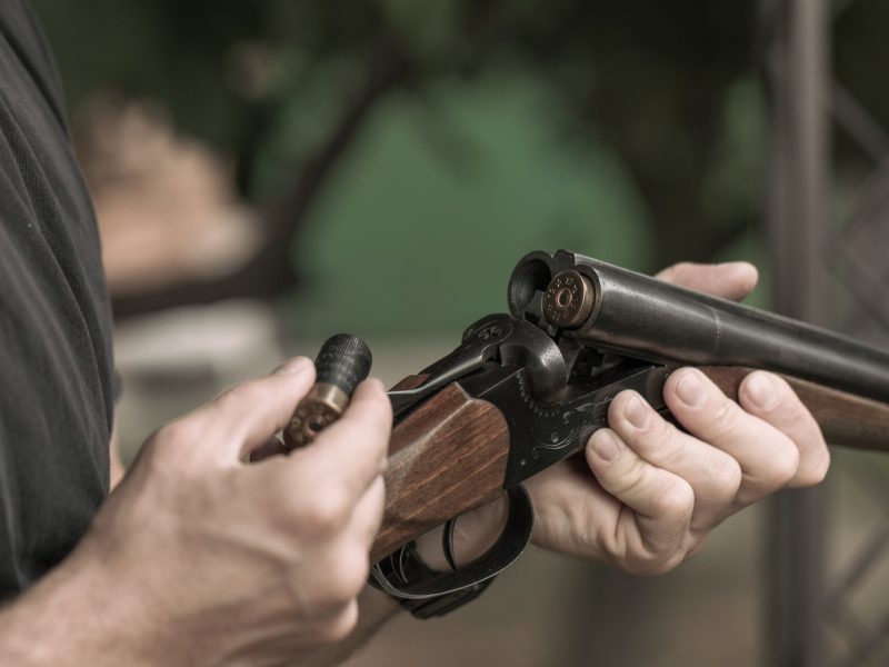 Man charging double-barreled hunting rifle closeup